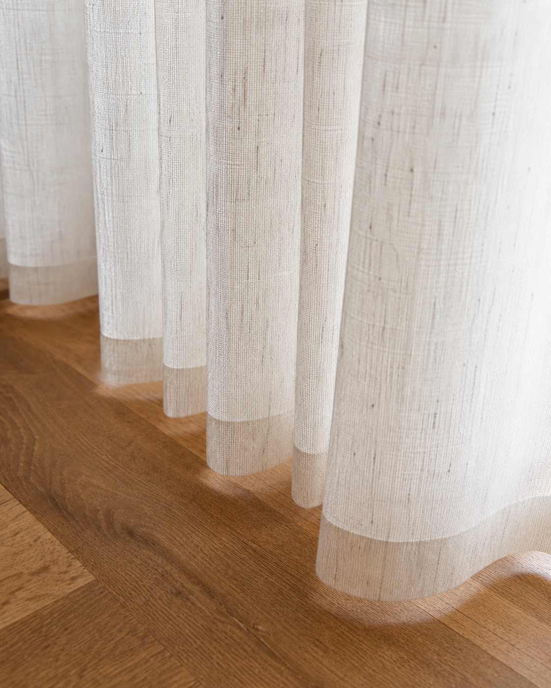 Linen look curtains with textured weave draping onto a timber floor