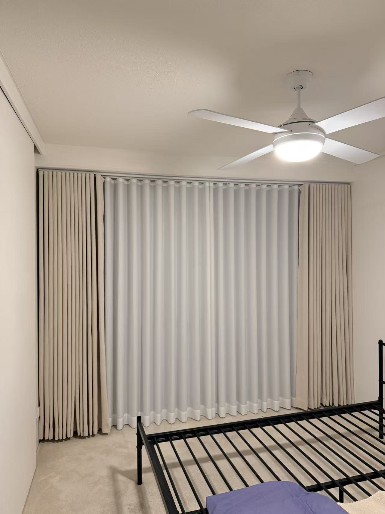 Layered sheer and blockout curtains installed in a Southport apartment bedroom