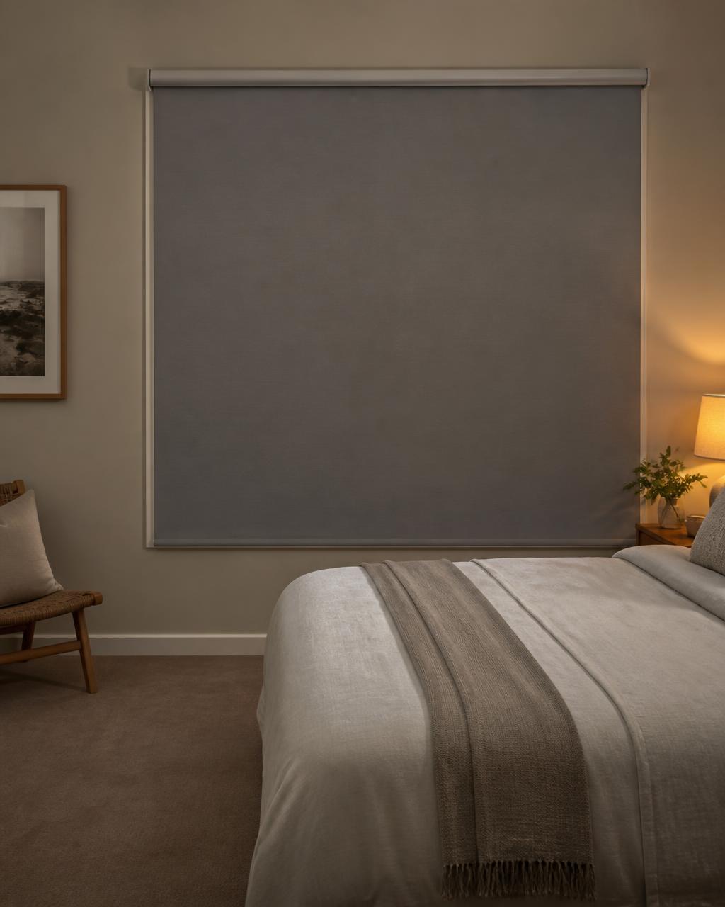 Blockout roller blind fully lowered in a calm bedroom at dusk
